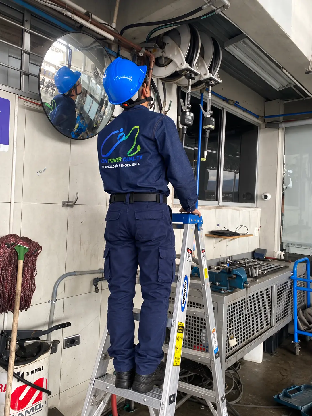 Técnico de ION Power Quality realizando mantenimiento eléctrico desde una escalera certificada